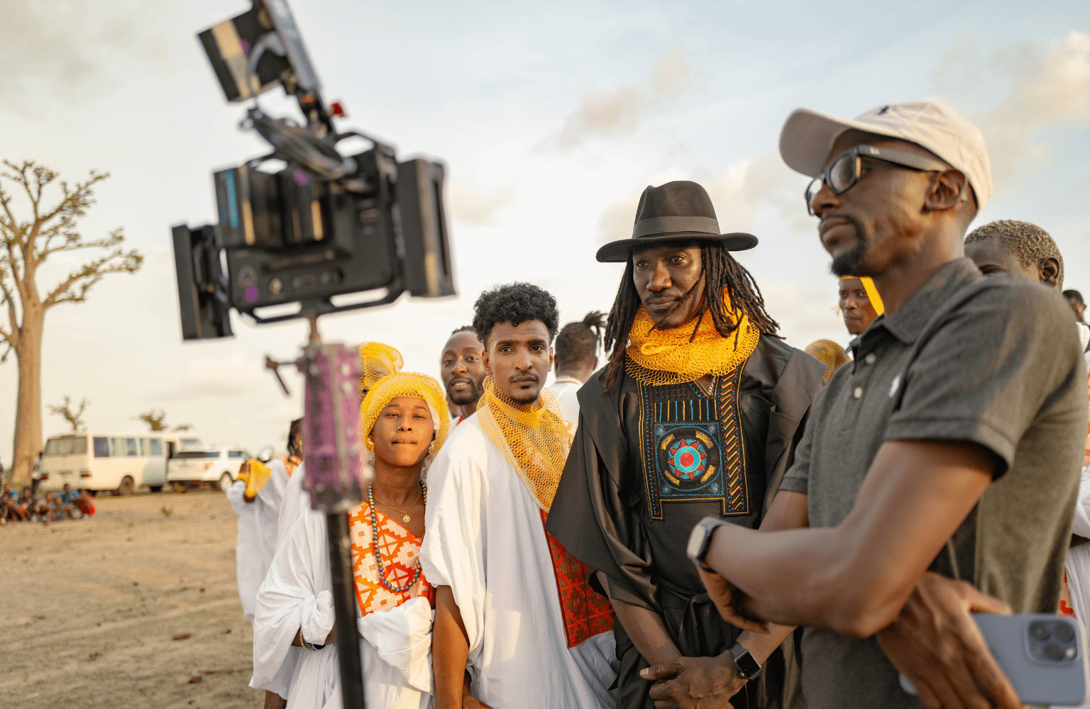 Mao Sidibé (center, in black outfit) watches the video feedback screen with the staff and dancers