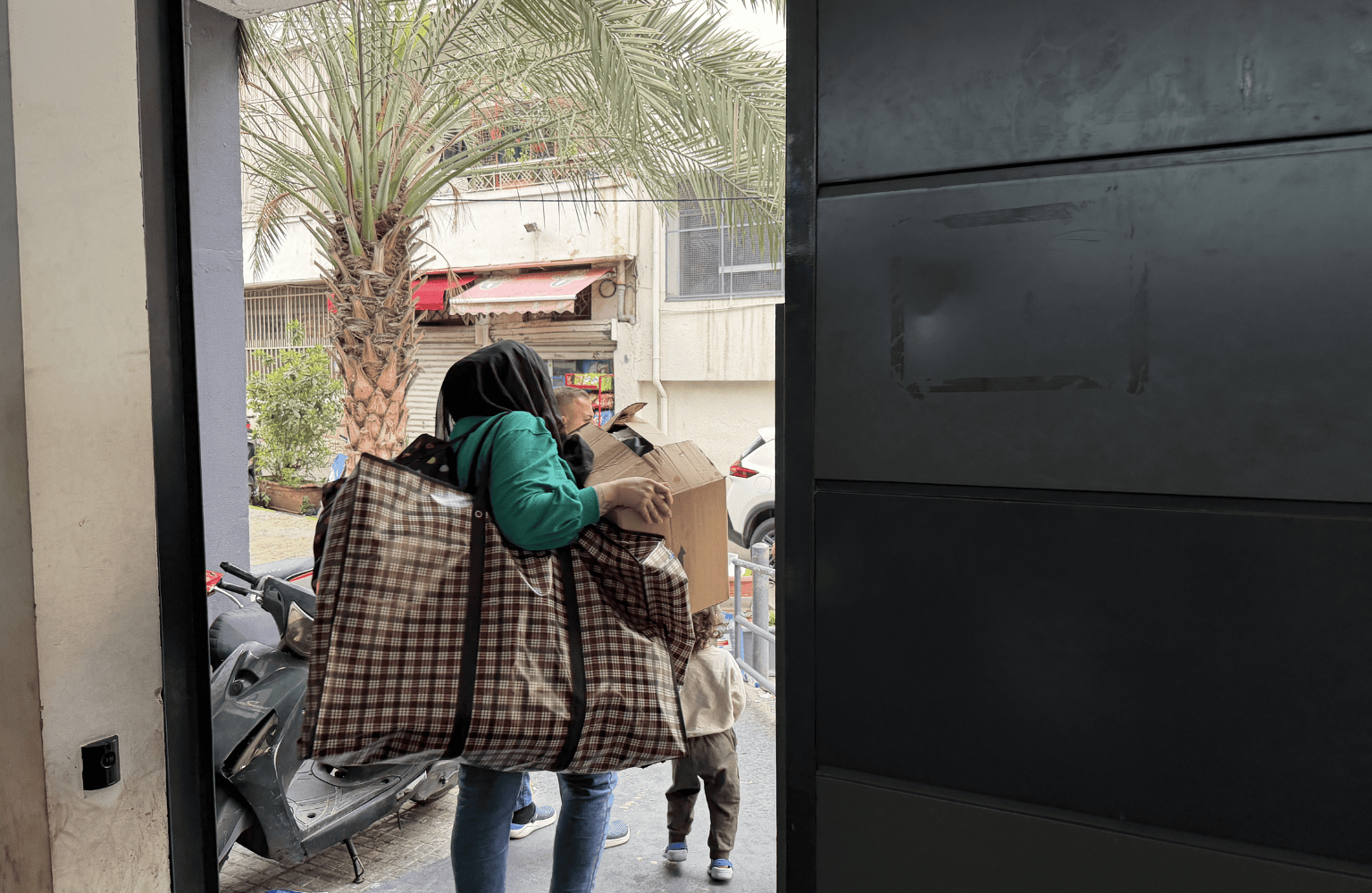 Women putting her bag in car leaving Lycee Abdel Kader shelter in Beirut, Lebanon