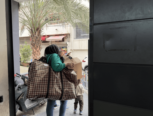 Women putting her bag in car leaving Lycee Abdel Kader shelter in Beirut, Lebanon